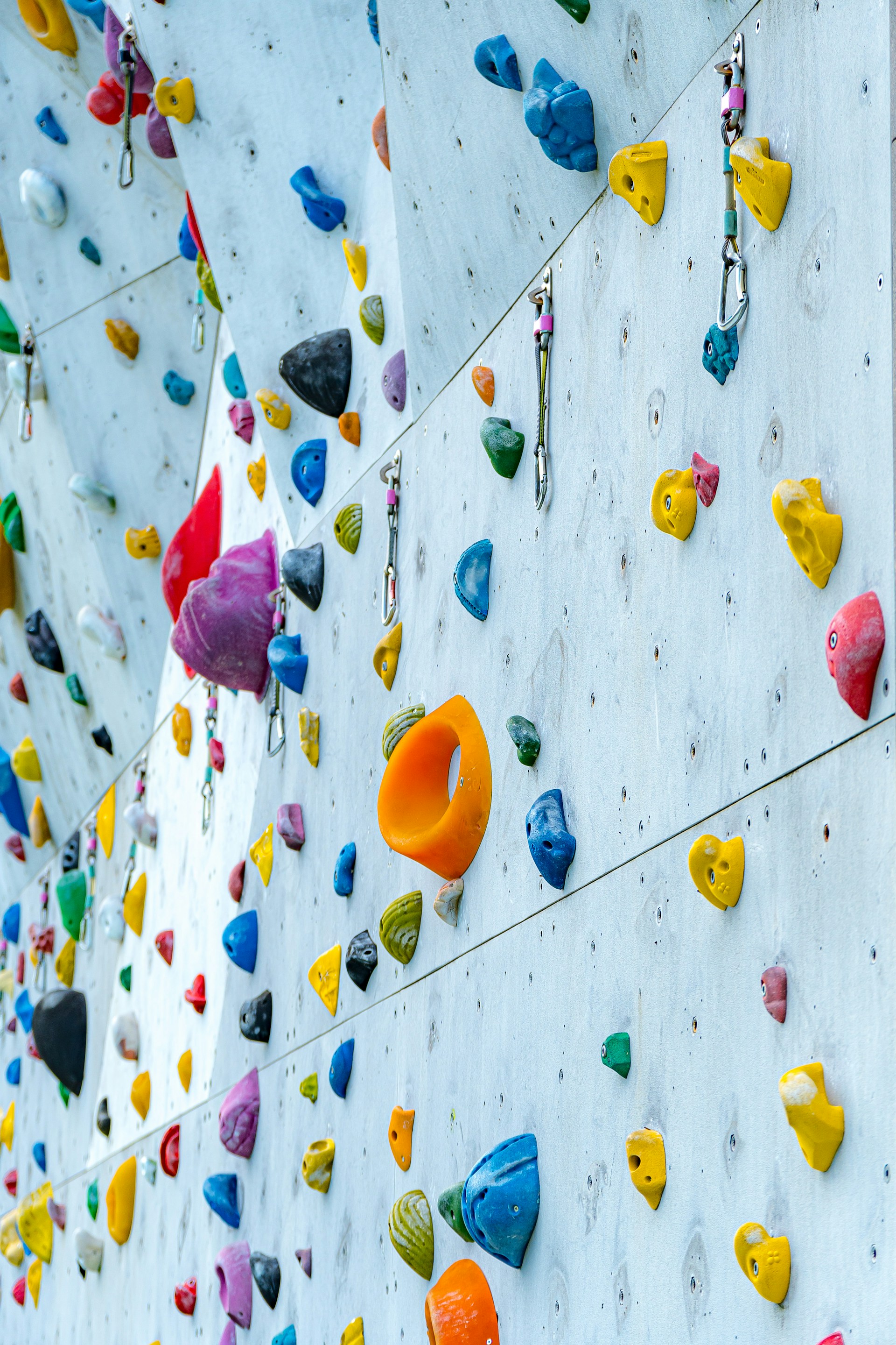 Rock climbing holds on a climbing wall, representing adventure sports activities available for booking through Kiosque